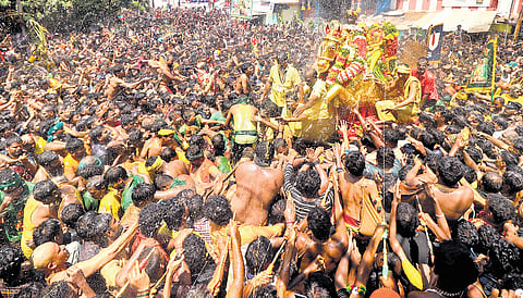 Hundreds of devotees performing Theerthavari, the ritual of spraying water on Lord Kallalagar, as the festival procession reached Ramarayar Mandapam in Madurai on Tuesday 