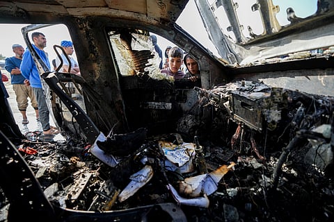 People inspect the site where World Central Kitchen workers were killed in Deir al-Balah, Gaza Strip.