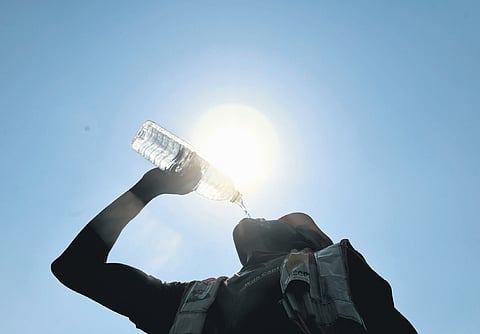 A construction worker quenches his thrust on a summer afternoon  in Hyderabad