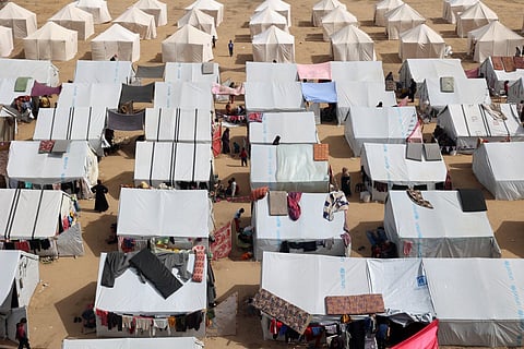 An aerial view shows displaced Palestinians outside tents at a makeshift camp for internally displaced in Rafah, in the southern Gaza Strip on March 27, 2024, amid the ongoing conflict between Israel and the militant group Hamas. 