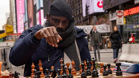 Tunde Onakoya, 29, a Nigerian chess champion and child education advocate, plays a chess game in Times Square, Friday, April 19, 2024 in New York. 
