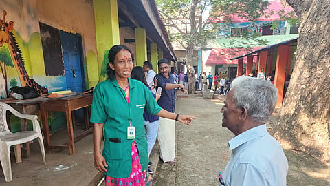Haritha Karma Sena worker Sindhu O giving directions to an elderly voter at a polling station located in Government High School, Kachani, in Thiruvananthapuram.