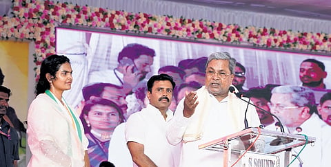 Chief Minister Siddaramaiah addresses a rally, as Congress Lok Sabha candidate Samyuktha Patil looks on, in Rabkavi, Bagalkot district, on Saturday  