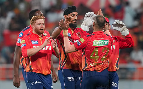 Punjab Kings bowler Arshdeep Singh, captain Shikhar Dhawan and teammates celebrate the wicket of Sunrisers Hyderabad batter Travis Head