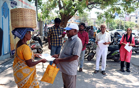 Members of the Vellore movement are distributing pamphlets about tree plantations in front of the Vellore Corporation on Tuesday