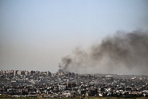 This picture taken from Israel's southern border with the Gaza Strip shows smoke billowing behind destroyed buildings due to Israeli strikes on the besieged Palestinian territory on April 2, 2024, amid the ongoing conflict between Israel and the militant group Hamas.