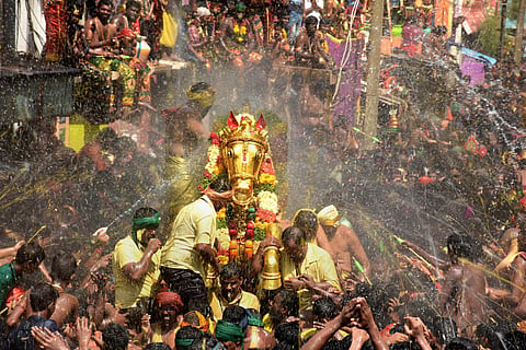Devotees splash water as Lord Kallazhagar enters the Vaigai River as part of Chithirai Festival of the famous Meenakshi Temple in Madurai 