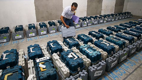A polling official checks Electronic Voting Machines (EVM) kept inside a strong room ahead of the first phase of voting for Lok Sabha elections, in Agartala,