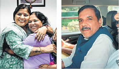 Anita Singh (left), wife of Sanjay Singh, celebrates at his residence 