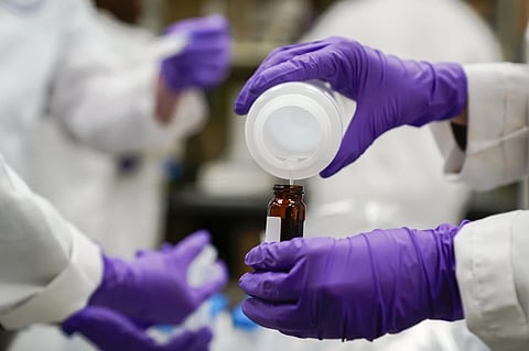 Eva Stebel, water researcher, pours a water sample into a smaller glass container for experimentation as part of drinking water and PFAS research at the U.S. Environmental Protection Agency Center For Environmental Solutions and Emergency Response on Feb. 16, 2023, in Cincinnati. 