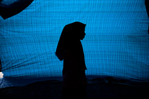 N, a 12-year-old ethnic Rohingya refugee identified by The Associated Press with only an initial, because she is a sexual assault survivor, stands in her tent at a temporary shelter on April 4, 2024.