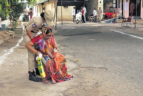 A policewoman helps a voter who has fallen while 
arriving at the poll booth at Chudi Bazar in Hyderabad on Monday 
