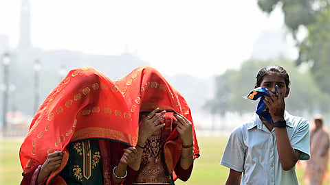 Women cover themselves with scarves on a hot summer day in Delhi.