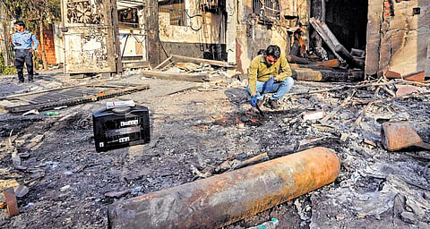 Forensic experts collect samples from the site of the fire accident 