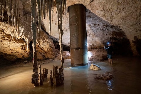 Engineer Guillermo D. Christy photographs a steel pillar filled with concrete that was installed inside the Aktun Tuyul cave system to support the Maya Train track on the outskirts of Playa del Carmen, Mexico.