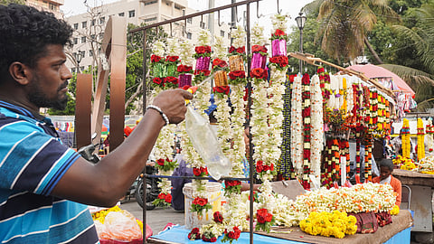 Flower vendor sprinkles water on the flowers in an attempt to keep them fresh amid extreme heat