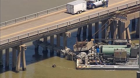 Oil spills into the surrounding waters after a barge hit a bridge in Galveston, Texas, on Wednesday, May 15, 2024.