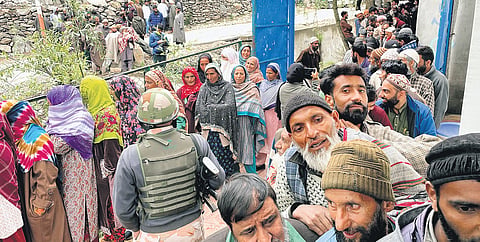 People stand in queues to cast their votes at a polling station in Fakeer Gujri on the outskirts of Srinagar, in the fourth phase of Lok Sabha elections on Monday