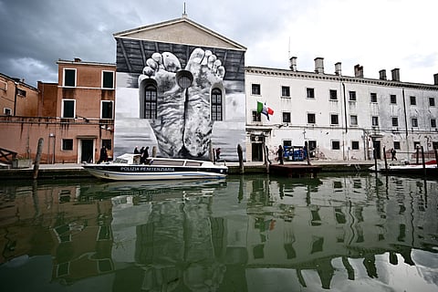 A mural by artist Maurizio Cattelan is seen outside Giudecca Women’s Prison hosting the Holy See pavilion during the pre-opening of the 60th Venice Biennale art show, on April 18, 2024 in Venice. 