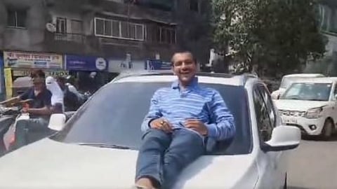 A man is seen lying on the bonnet of a BMW driven by a 17-year-old in Mumbai.
