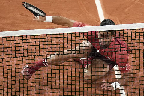 Serbia's Novak Djokovic slips when playing a shot close to the net during his first round match of the French Open tennis tournament against France's Pierre-Hugues Herbert at the Roland Garros stadium in Paris, Tuesday, May 28, 2024.