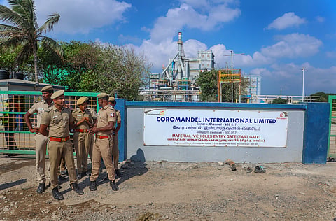 Police personnel stand guard outside a plant of Coromandel International Ltd