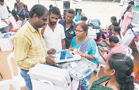 Polling staff check EVMs and VVPATs at a distribution centre at IGMC Stadium in Vijayawada on Sunday I Prasant Madugula