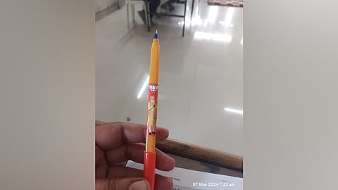 A polling agent's pen bearing a lotus symbol and a photo of PM Narendra Modi. 