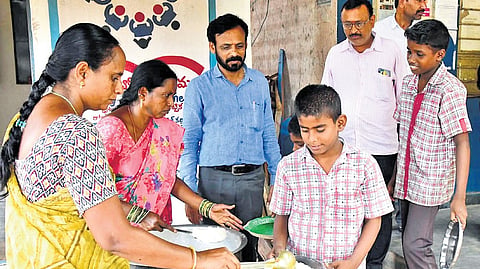 Students being served mid-day meals on Wednesday, the first day of school reopening 