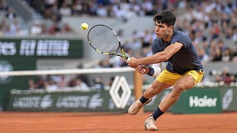  Spain's Carlos Alcaraz Garfia plays a backhand return to Greece's Stefanos Tsitsipas during their men's singles quarter final match at the Roland Garros Complex in Paris on June 4, 2024. 