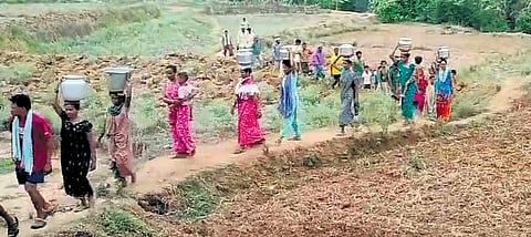 Tribals of Dandu Suraguda village in Kurupam Mandal walking 2 km to fetch water from a temporary well dug in the district. 