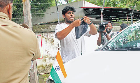A KSU activist ties a black flag on General Education Minister V Sivankutty’s car outside his official residence, Rose House, in Thiruvananthapuram on Sunday. 
