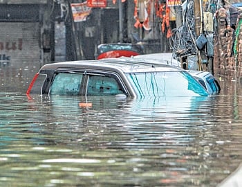 A car is seen submerged in water as heavy rains caused water logging in the capital city on Friday. 
