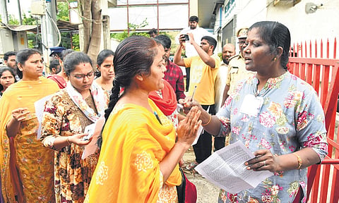 Candidates wait outside an exam centre in Hyderabad on Sunday 