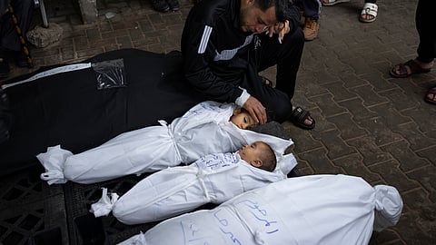 A man mourns over the bodies of his two daughters who were killed in the Israeli bombardment of the Gaza Strip, at a hospital morgue in Rafah.