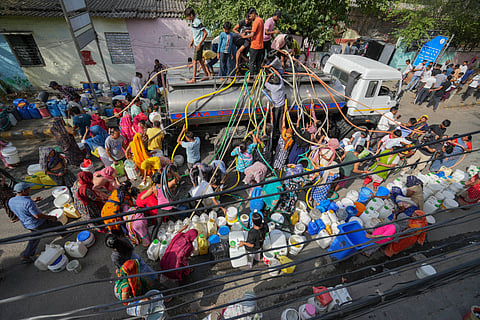  People collect drinking water from a tanker amid ongoing Delhi water crisis, at Vivekanand camp in New Delhi, Thursday.