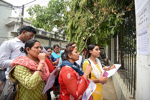 Aspirants search their roll numbers for seats before entering an examination center to appear in the UGC-NET exam, at AN college in Patna, Tuesday, June 18, 2024. 