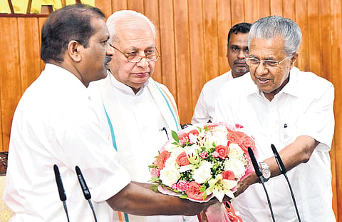 Chief Minister Pinarayi Vijayan offers a bouquet to O R Kelu, who was sworn in as a minister at Raj Bhavan in Thiruvananthapuram on Sunday. Governor Arif Mohammed Khan is also seen 