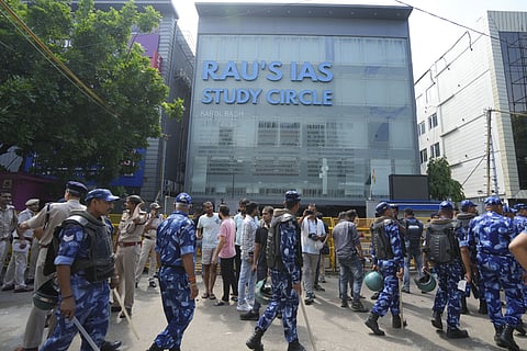Security personnel stand guard near a UPSC exam coaching centre after three civil services aspirants died when the basement of the coaching centre was flooded by rainwater, in New Delhi, Sunday, July 28, 2024. 