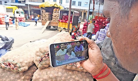 A man watches Finance Minister Nirmala Sitharaman presenting the Union Budget 2024-25 on his mobile phone, at APMC Yard in Bengaluru on Tuesday