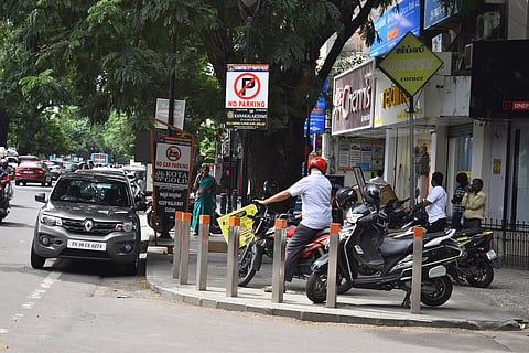 The pedestrian pathways at the DB Road in RS Puram have turned into a parking spot for motorists. 