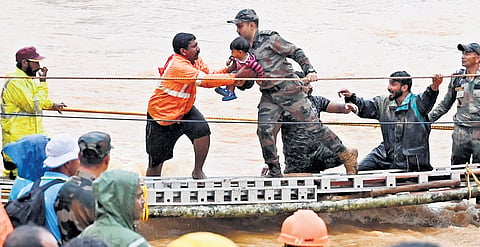 Workers rescue a child from the Mundakkai area 