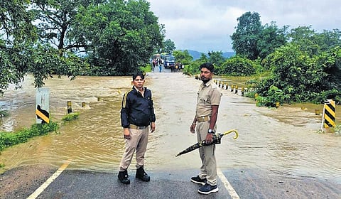 Police personnel deployed on a bridge to prevent vehicles from plying on it 