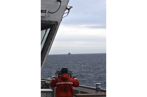 US coast guard officer viewing the Chinese naval ship which came across the U.S. exclusive economic zone