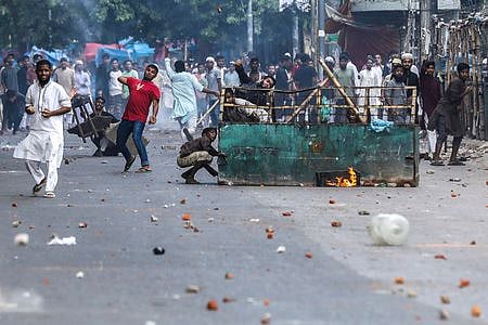 Protesters pelt stones as they clashed with police during the ongoing anti-quota protest in Dhaka on July 19, 2024. 