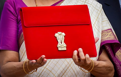 Union Finance Minister Nirmala Sitharaman carries a red pouch carrying the Budget documents, outside the Finance Ministry in North Block before leaving for the Parliament where she will table the Union Budget 2024-25, in New Delhi, Tuesday, July 23, 2024.