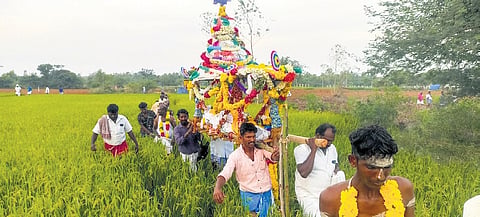 Residents of Mattaiyanpatti carrying the body of a villager through a field 