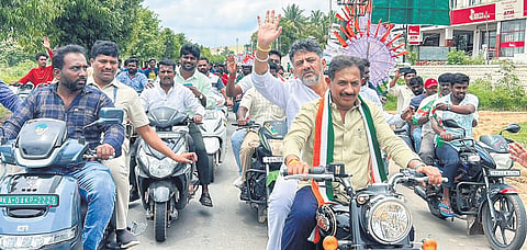 Deputy Chief Minister DK Shivakumar rides pillion after launching the Congress’ Janandolana, a series of public meetings to counter the 
BJP-JDS padayatra, in Bidadi in Bengaluru on Friday   