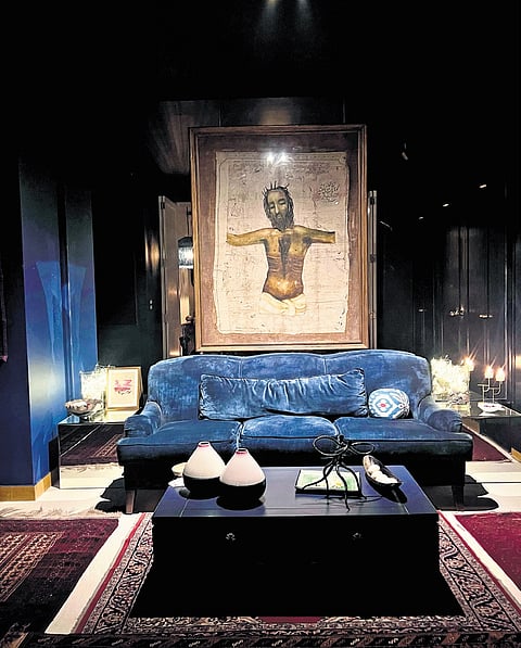 In this living room, everything (from the ceiling to the walls) has been painted deep blue to match the colour of the sofa. This keeps the focus on the Anjolie Ela Menon painting in the foreground. 