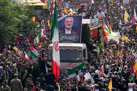 Iranians follow a truck, center, carrying the coffins of Hamas leader Ismail Haniyeh and his bodyguard who were killed in an assassination blamed on Israel on Wednesday, during their funeral ceremony at Enqelab-e-Eslami (Islamic Revolution) Sq. in Tehran, Iran, Thursday, Aug. 1, 2024. 